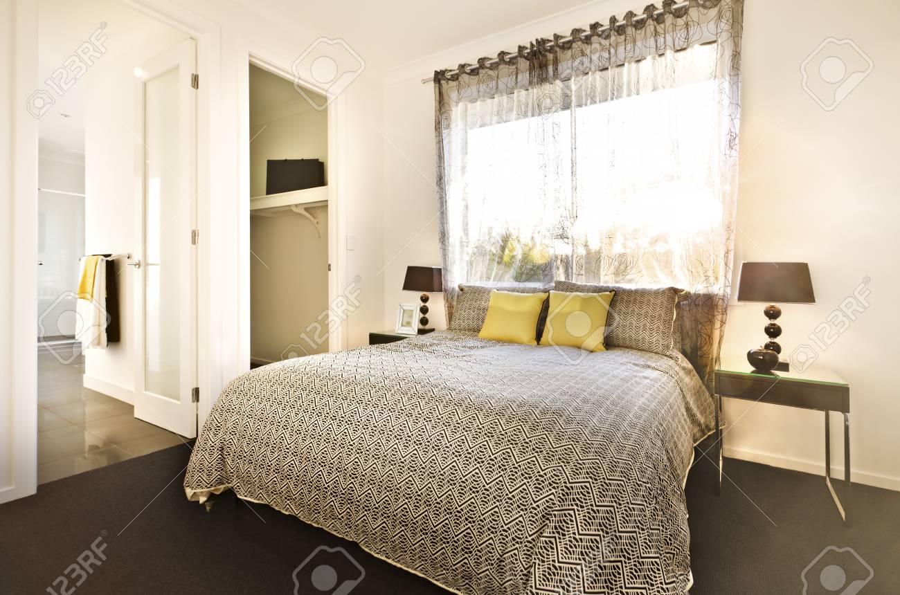 パターンと豪華なベッドルームはカーペットの上ランプ カーテンの窓の近くに枕とベッドの上のシーツを設計 の写真素材 画像素材 Image