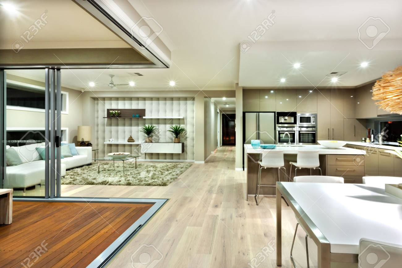 高級住宅のいくつかの領域には リビング ルーム キッチンが含まれています 木製の床は 家全体に広がっていると外に方法を見ることができる 冷蔵庫とオーブンの蛇口とカリスのような台所とソファやテーブルのような家具があります の写真素材 画像素材 Image