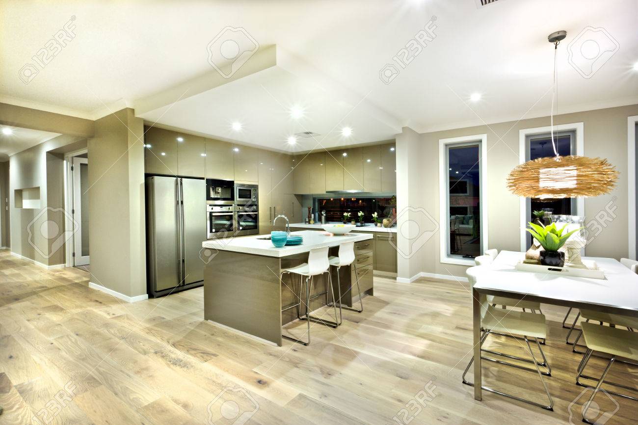 Modern kitchen and dinning area interior view of a modern house with lights on at night