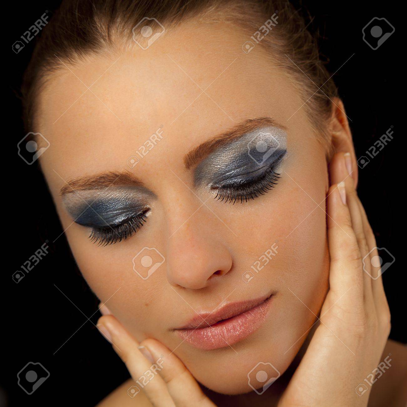 Belle Jeune Femme Portant Le Maquillage Bleu Et Rouge à Lèvres Rose Tenant Ses Mains à Son Visage