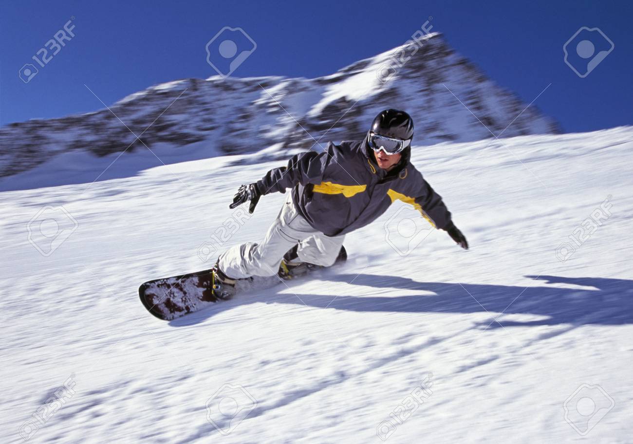 person snowboarding down mountain