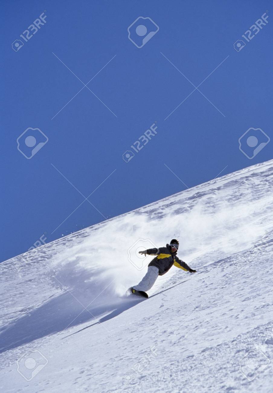 person snowboarding down mountain
