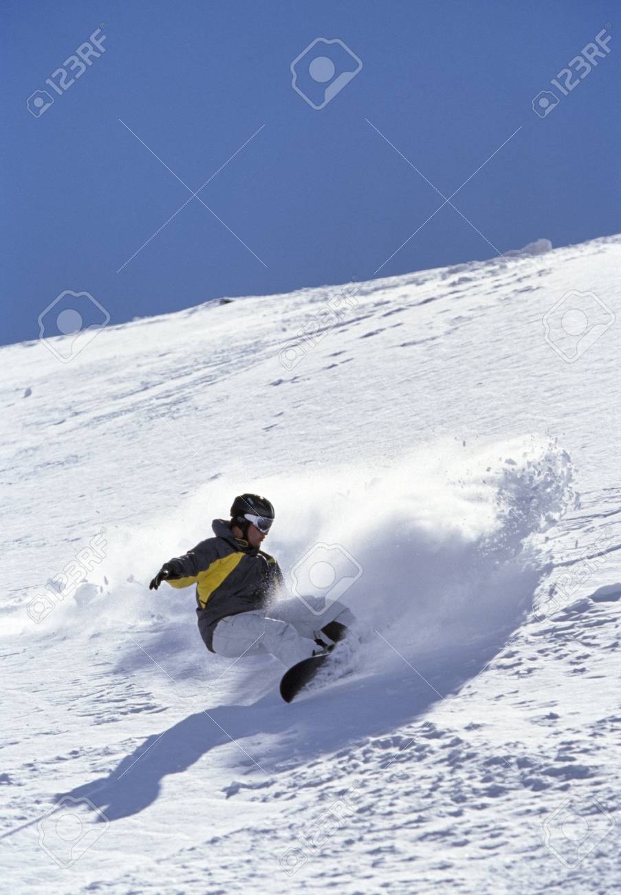 person snowboarding down mountain