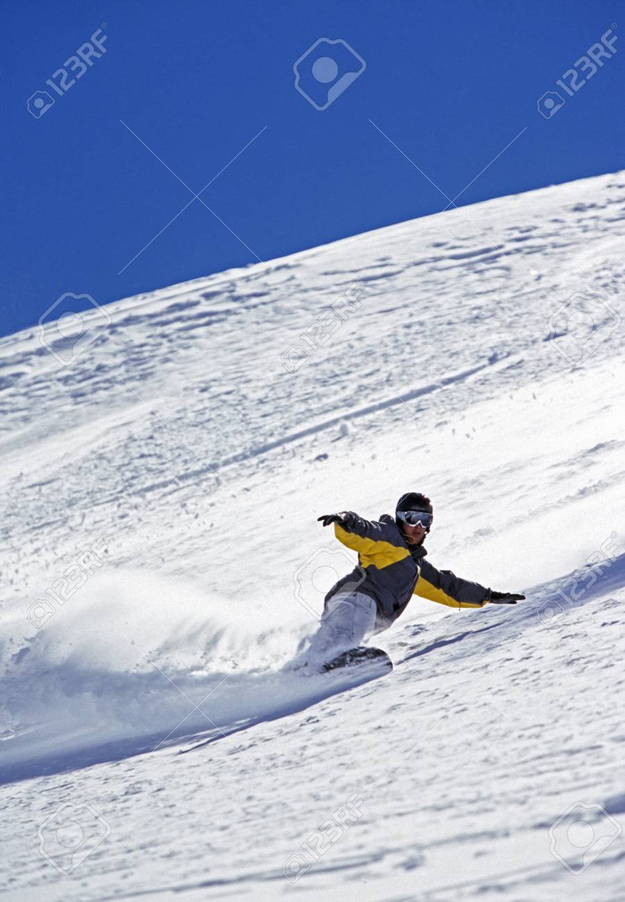 person snowboarding down mountain