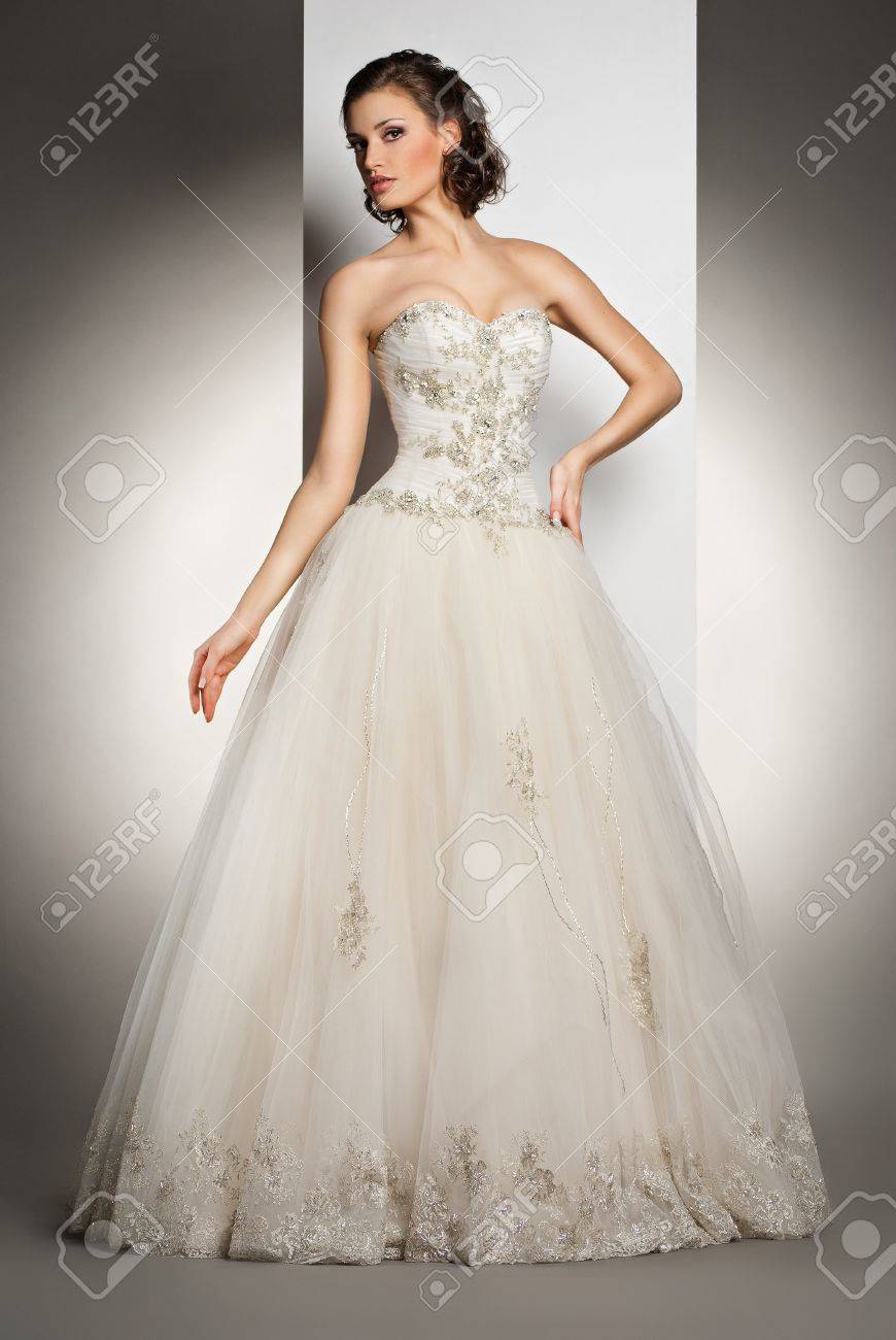 灰色の背景の上のウェディング ドレスでポーズ美しい若い女性 の写真素材 画像素材 Image