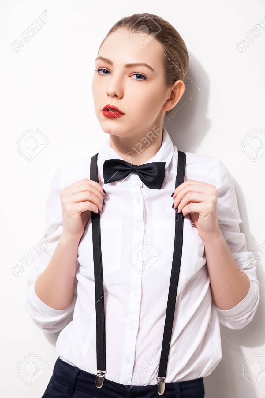 白い背景の上の彼女の蝶ネクタイを保持してエレガントな若い女性 の写真素材 画像素材 Image