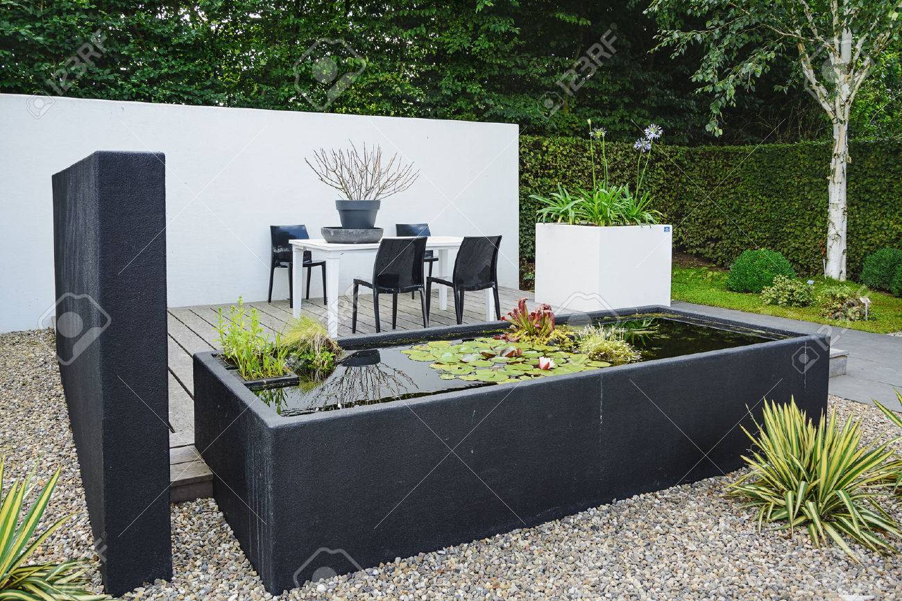 Appeltern, The Netherlands, July 22, 2015: The Gardens of Appeltern is the inspiration garden park in the Netherlands. In this picture a garden with modern garden furniture and trendy pond. - 58094791 Appeltern, The Netherlands, July 22, 2015: The Gardens of Appeltern is the inspiration garden park in the Netherlands. In this picture a garden with modern garden furniture and trendy pond. - 58094791