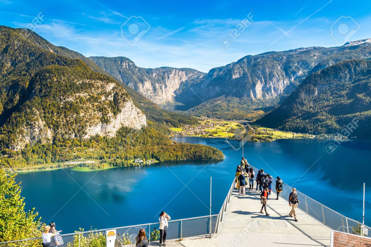 Hallstatt, Austria - OCT 2018: Tourists take photos and enjoy the view of the mountains and lake Hallstatter See from the World Heritage View Point. Popular tourist destination in Austrian Alps. - 133913400 Hallstatt, Austria - OCT 2018: Tourists take photos and enjoy the view of the mountains and lake Hallstatter See from the World Heritage View Point. Popular tourist destination in Austrian Alps. - 133913400