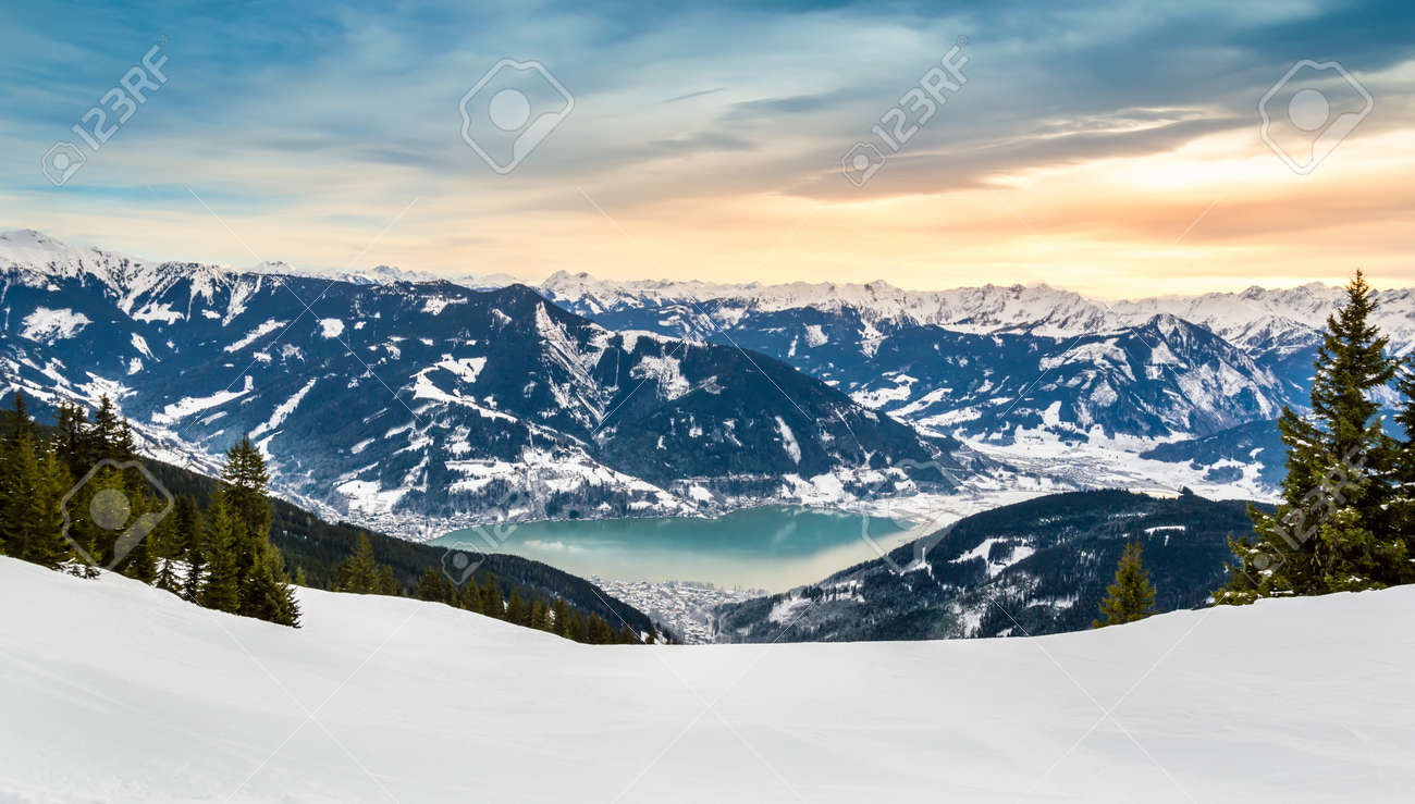 Zell Am See And Schmitten Town At Zeller Lake In Winter. View From  Schmittenhohe Mountain, Snowy Ski Resort Slope In The Alps Mountains,  Austria. Stunning Landscape, Snow And Sunset Sky Near Kaprun, image size:1300x739