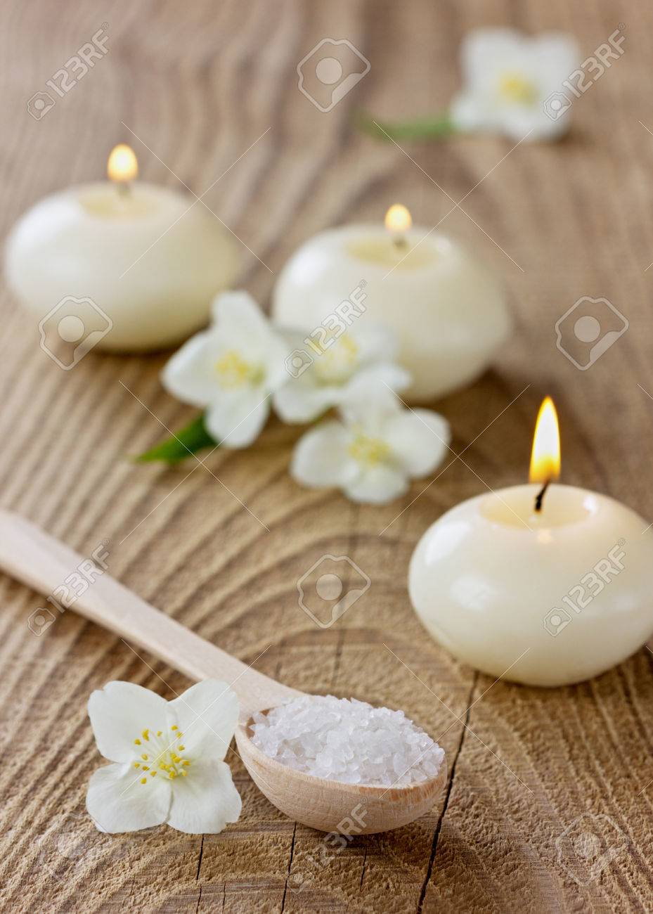 archivio fotografico composizione spa con bagno di sale marino del cucchiaio di legno fiori di gelsomino e candele accese su una superficie rustica