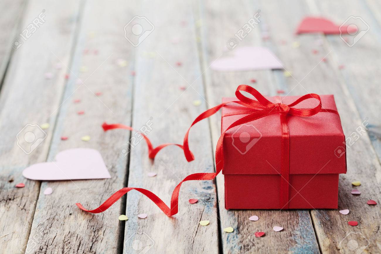 Gift box with red bow ribbon and paper heart on wooden table for Valentines day - 50528720 Gift box with red bow ribbon and paper heart on wooden table for Valentines day - 50528720