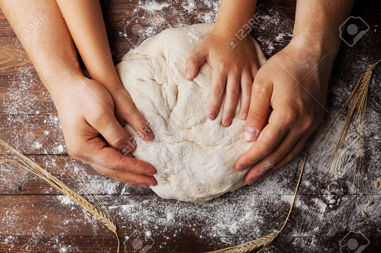 Father and child hands prepares the dough with flour, rolling pin and wheat ears on rustic wooden table from above. Homemade pastry for bread or pizza. Bakery background. - 62316205 Father and child hands prepares the dough with flour, rolling pin and wheat ears on rustic wooden table from above. Homemade pastry for bread or pizza. Bakery background. - 62316205