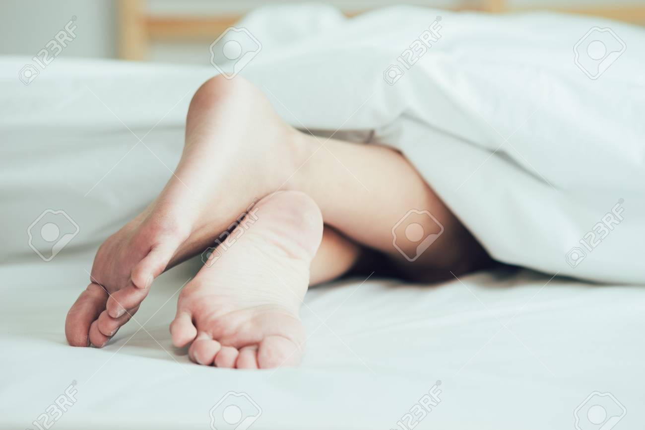 Stock P O The Feet Or Foot Of Couples Sleeping On The Bed And Cover By The White Blanket On A Bright Sunday Morning Stock P O The Feet Or Foot Of Couples Sleeping On The Bed And Cover By The White Blanket On A Bright Sunday Morning