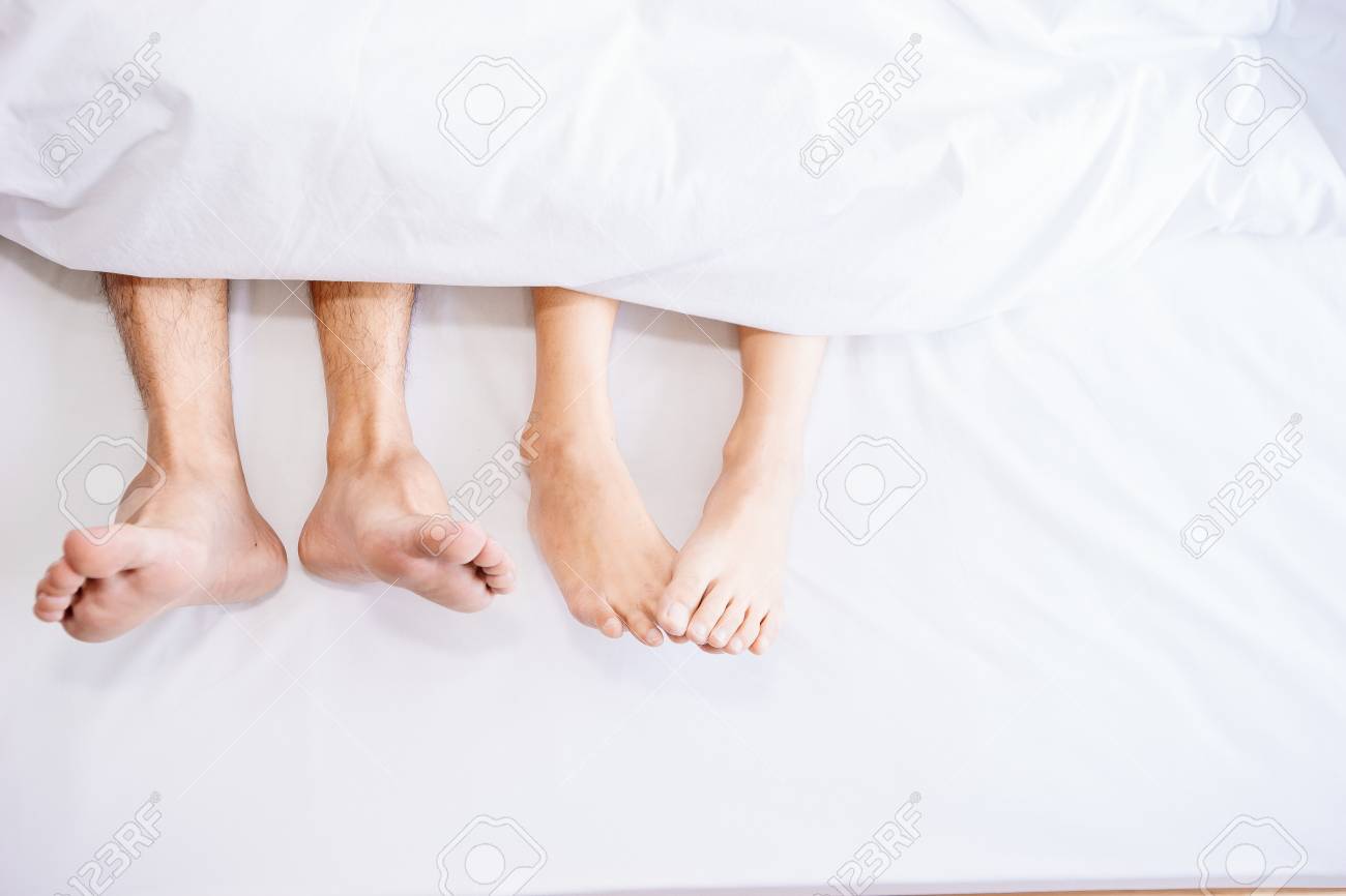 Stock P O The Feet Or Foot Of Couples Sleeping On The Bed And Cover By The White Blanket On A Bright Sunday Morning Stock P O The Feet Or Foot Of Couples Sleeping On The Bed And Cover By The White Blanket On A Bright Sunday Morning