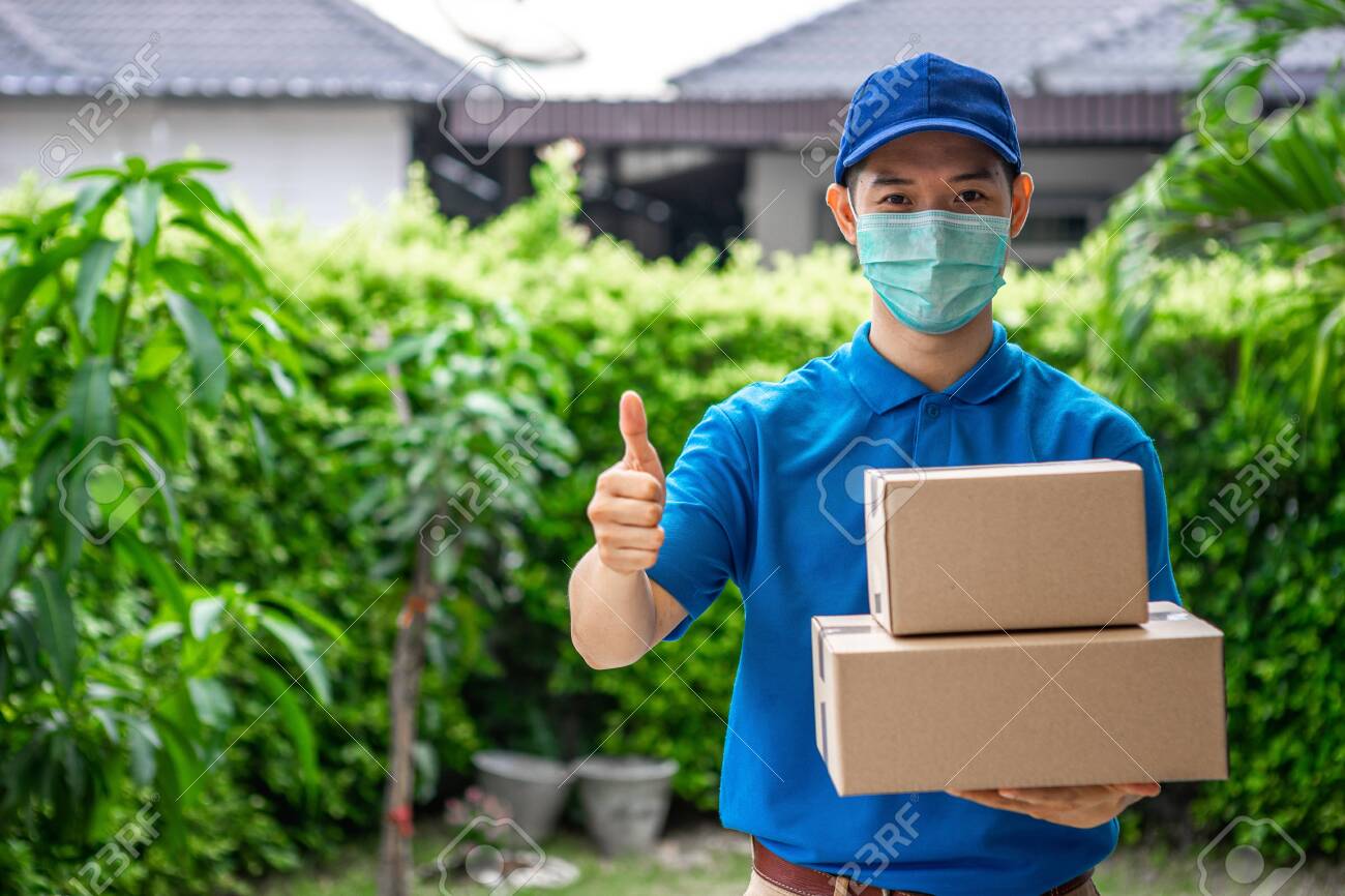 Asian deliveryman is delivering parcel to house her to sign to receive the product After she ordered online during the outbreak of the coronavirus or Covid-19 virus. - 148855852 Asian deliveryman is delivering parcel to house her to sign to receive the product After she ordered online during the outbreak of the coronavirus or Covid-19 virus. - 148855852