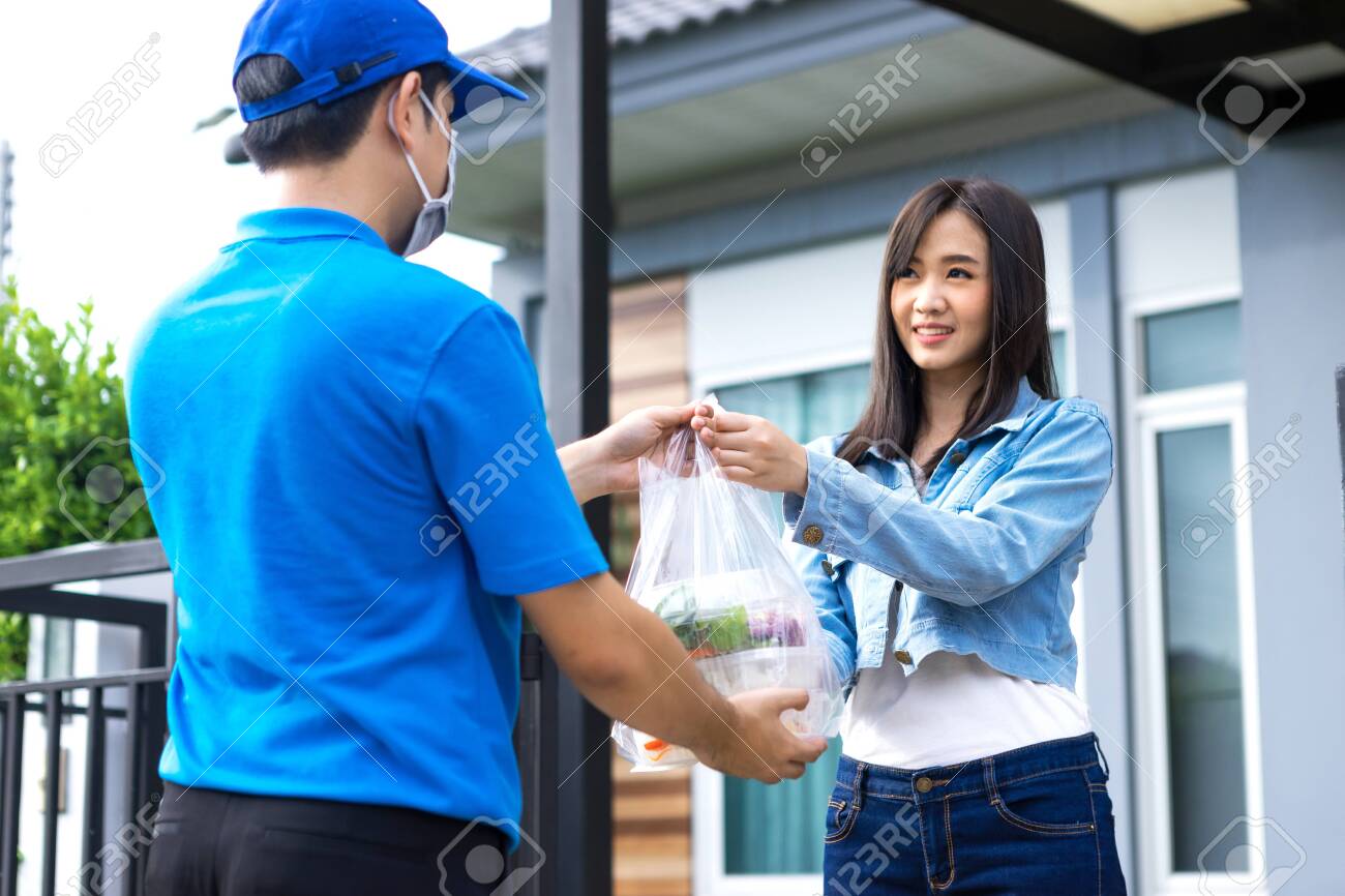 Asian delivery man delivering food, fruit, joice and vegetable to customer home - online grocery shopping service concept - 149473792 Asian delivery man delivering food, fruit, joice and vegetable to customer home - online grocery shopping service concept - 149473792