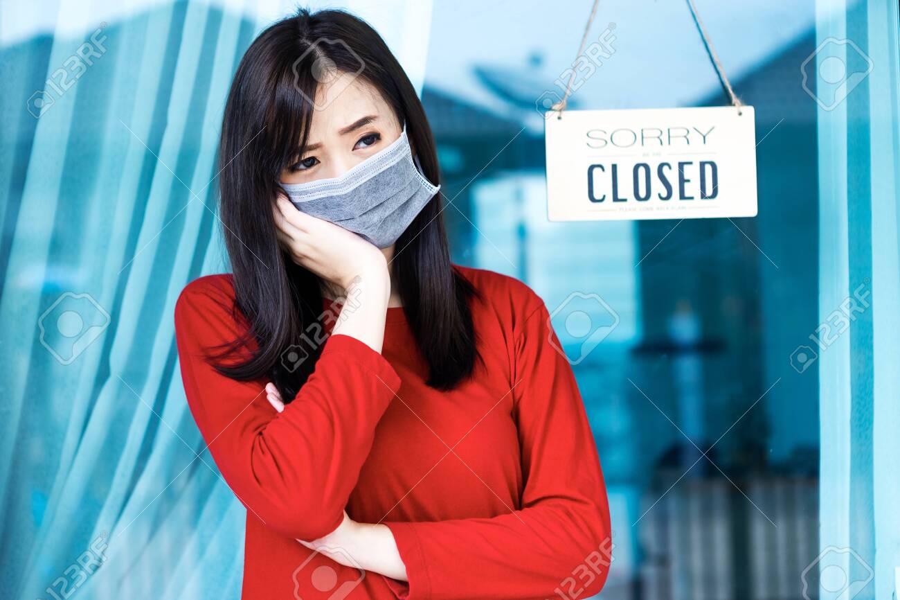 Asian woman shop owner hanging label 'Sorry we are Closed'. She close her shop under pandemic coronavirus - 149473802 Asian woman shop owner hanging label 'Sorry we are Closed'. She close her shop under pandemic coronavirus - 149473802