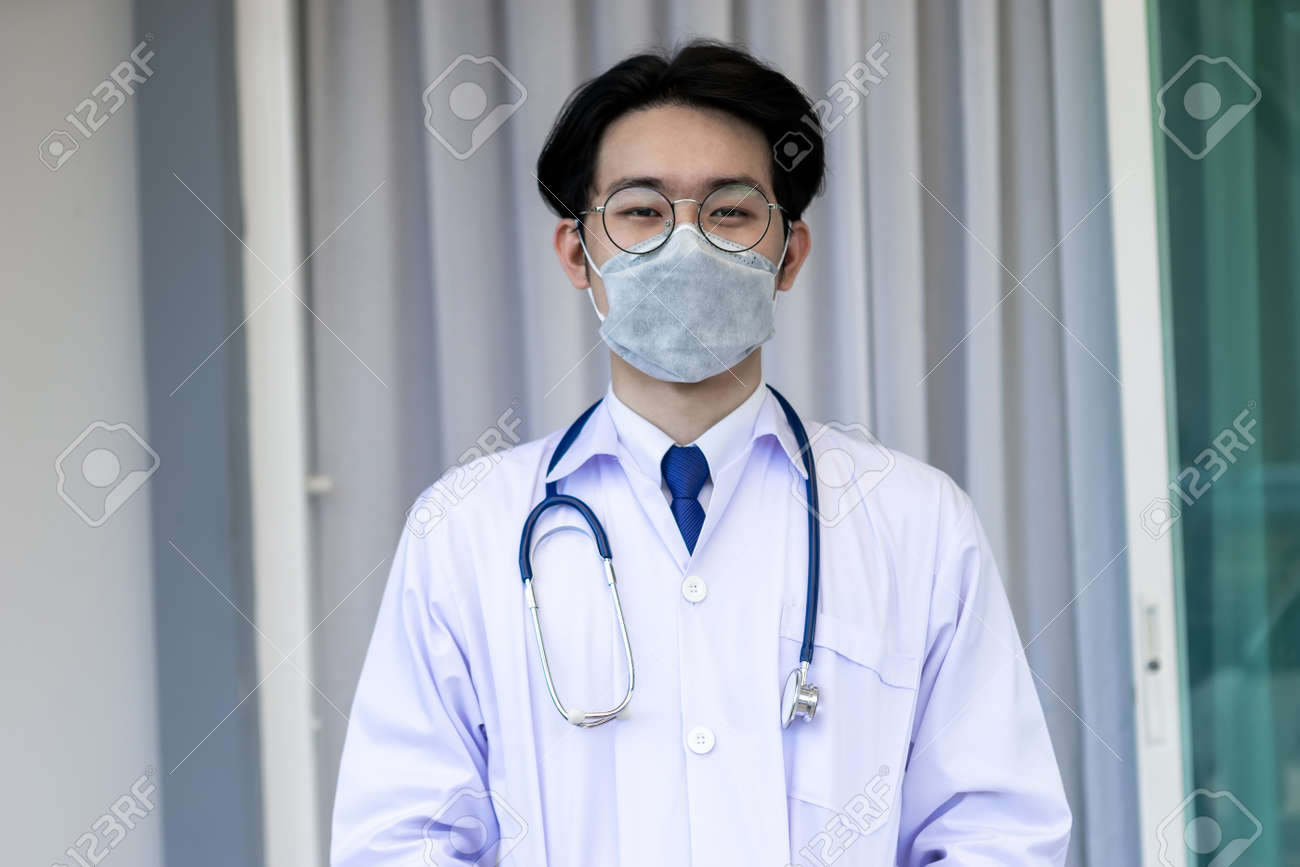 Portrait of Asian doctor man wearing stethoscope white coat standing in modern hospital. - 155233950 Portrait of Asian doctor man wearing stethoscope white coat standing in modern hospital. - 155233950
