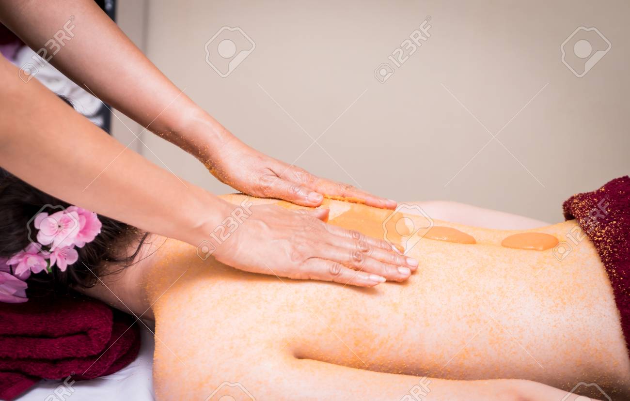 女性が彼女の背中にオレンジ色の塩のスクラブを受信します の写真素材 画像素材 Image