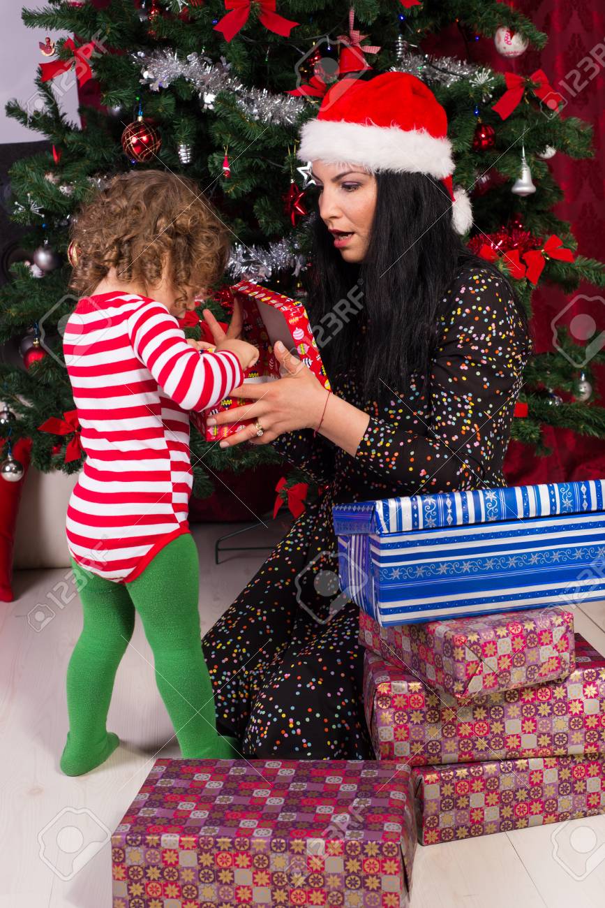 amazed mother and toddler boy opening christmas gifts under tree toddler boys christmas gifts