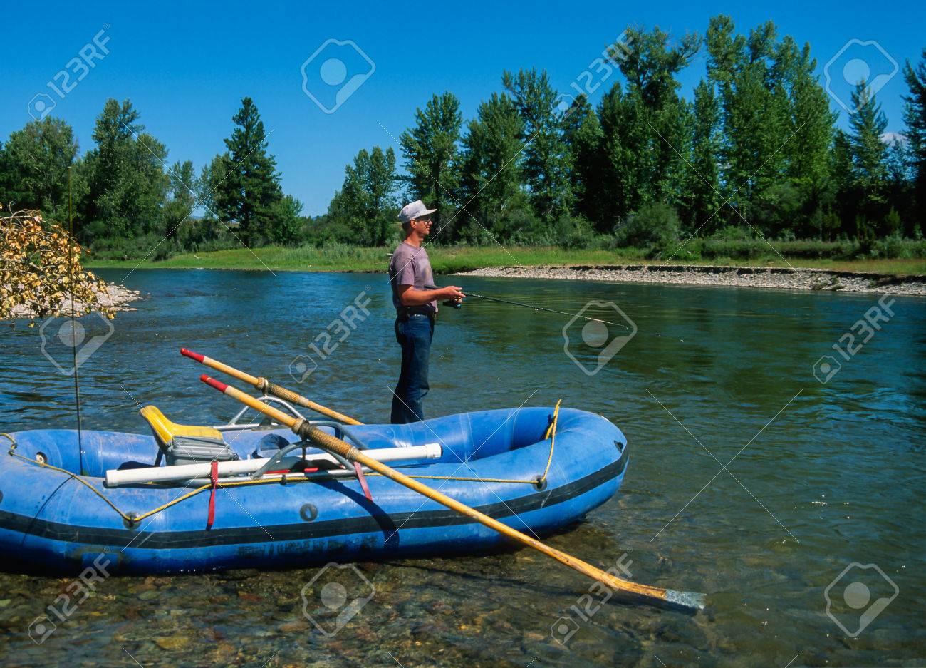 垂木の豪華な夏の日にブラックフットの川を釣りします 川下のコットンウッドの木と緑の草が茂った銀行大きな鮮やかな青い空 美しいクリア実行中川 A 川実行 It 小説に影響を与えた フレームとオールのボートが付いているいかだ の写真素材 画像素材 Image