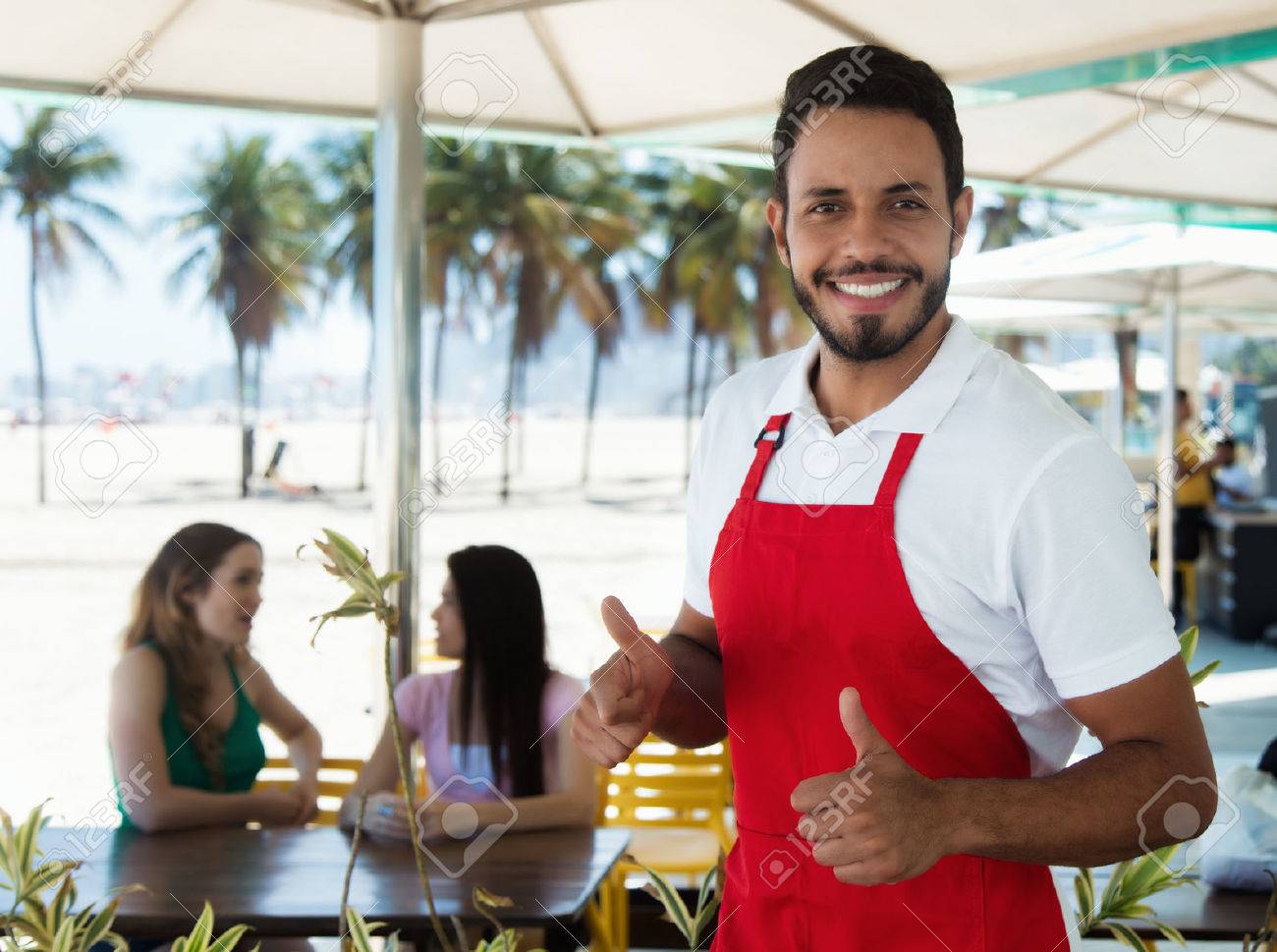 Laughing waiter of a cocktail bar at beach - 67418269 Laughing waiter of a cocktail bar at beach - 67418269