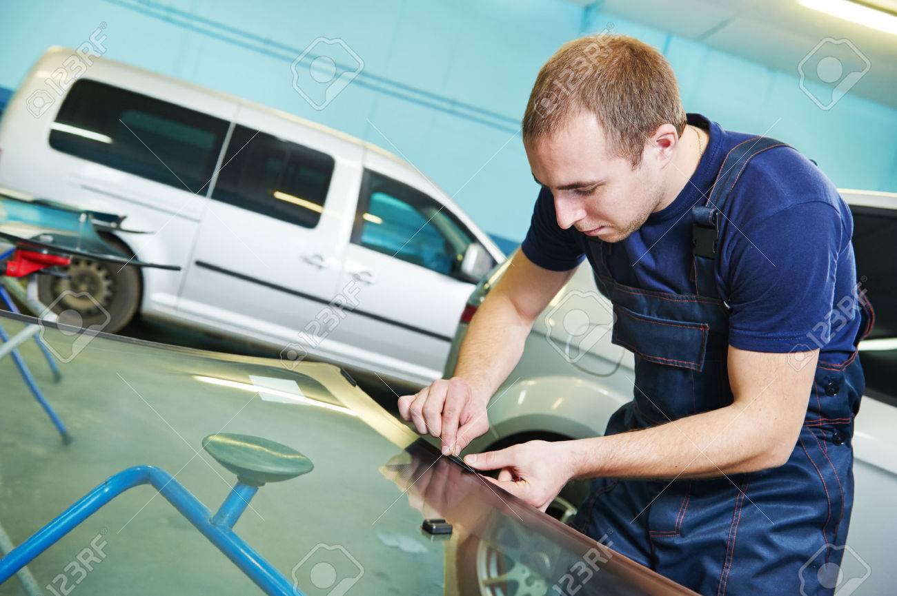 自動車ガラス風防あるいはインストールする前に自動サービス ステーションのガレージで車のフロント ガラスに接着剤を追加します の写真素材 画像素材 Image