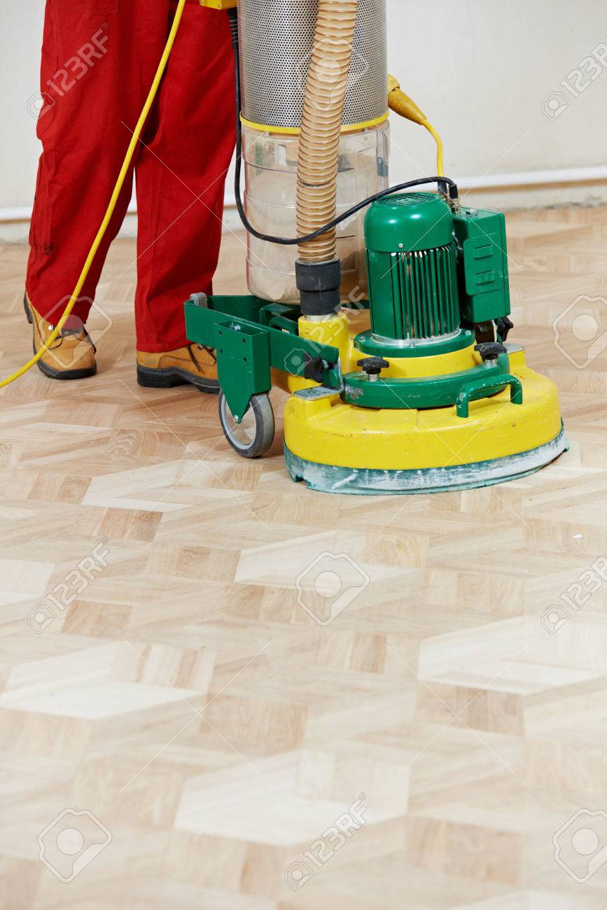 Carpenter Doing Parquet Wood Floor Polishing Maintenance Work
