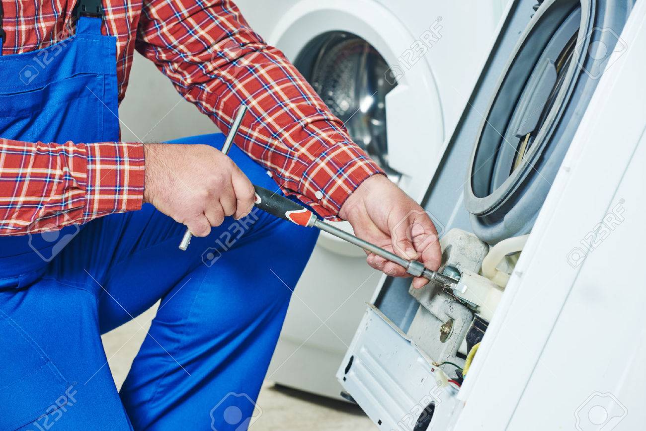 Washing machine repair. Repairer hands with screwdriver disassembling damaged unit for repair - 50038136 Washing machine repair. Repairer hands with screwdriver disassembling damaged unit for repair - 50038136