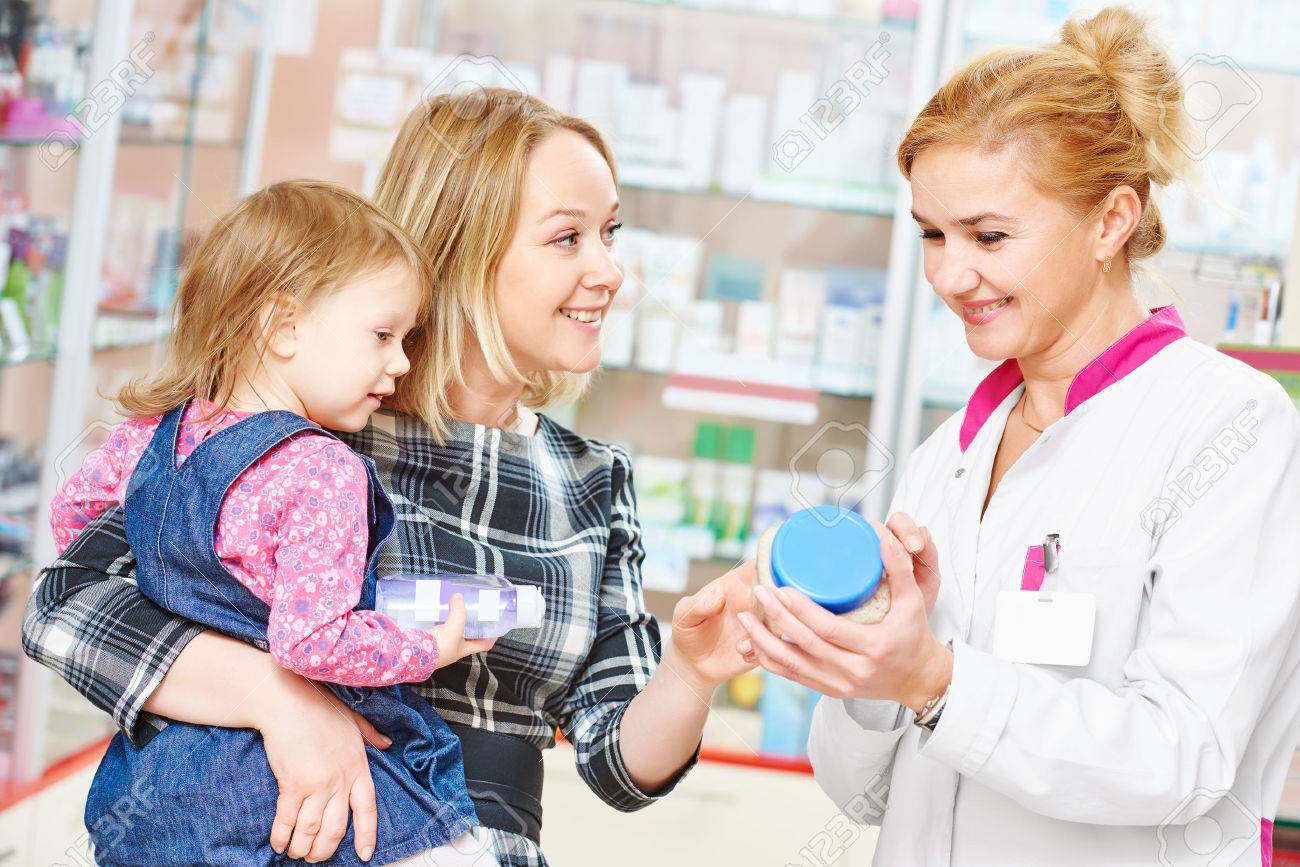 pharmacist chemist woman demonstrating vitamin to child girl with mother in pharmacy drugstore. family health - 55591245 pharmacist chemist woman demonstrating vitamin to child girl with mother in pharmacy drugstore. family health - 55591245