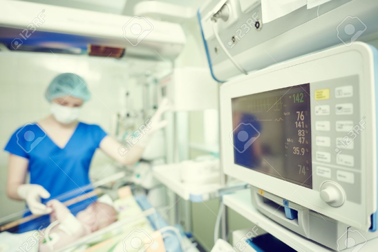 Surgery and intensive care unit. Female doctor or nurse in surgical child neonatal hospital with artifical lung ventilation device - 56570086 Surgery and intensive care unit. Female doctor or nurse in surgical child neonatal hospital with artifical lung ventilation device - 56570086