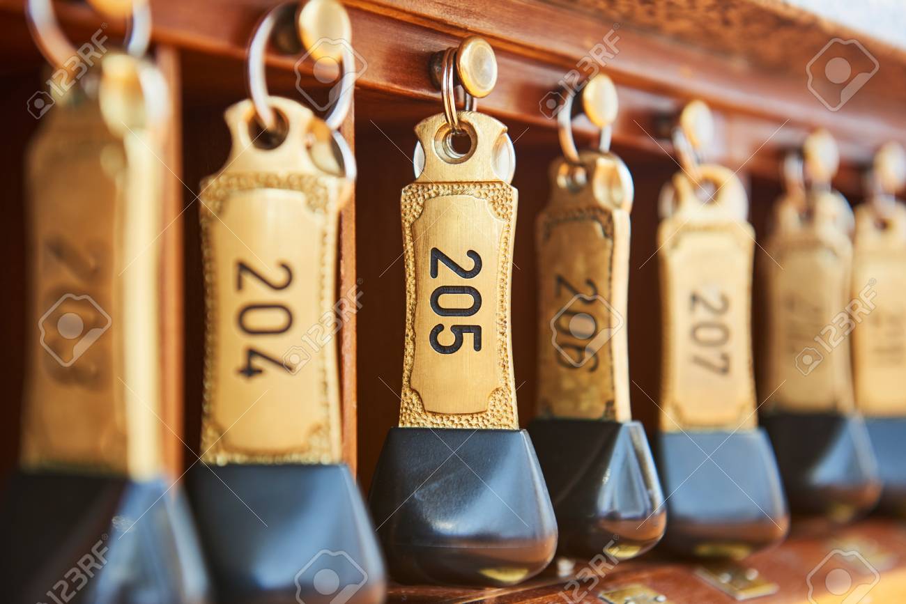 hotel bronze keys with room numbers hanging at reception desk motel desk