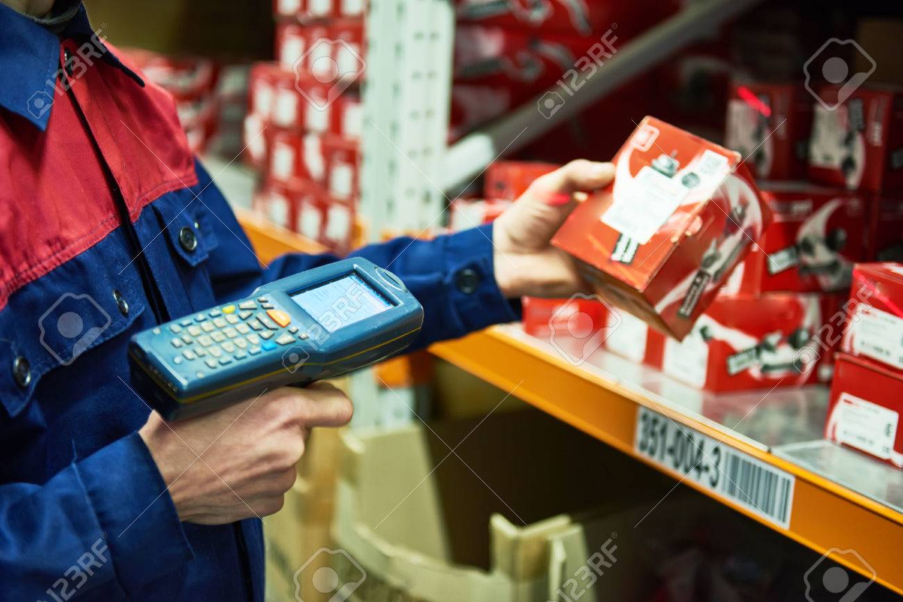 warehouse worker scanning automobile spare part with laser barcode scanner - 77052087 warehouse worker scanning automobile spare part with laser barcode scanner - 77052087