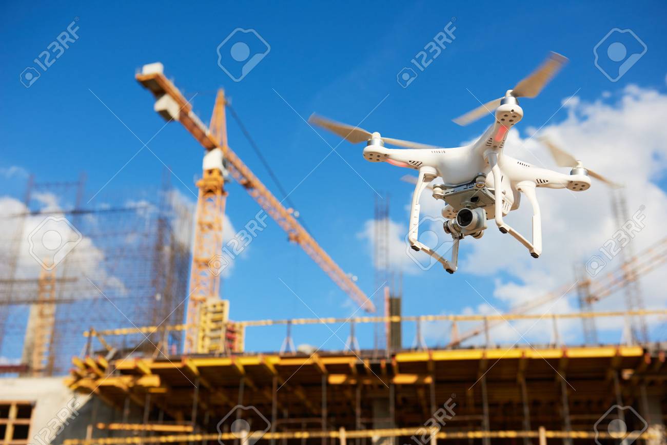 Drone hovering over construction site. video surveillance or industrial inspection - 82998288 Drone hovering over construction site. video surveillance or industrial inspection - 82998288