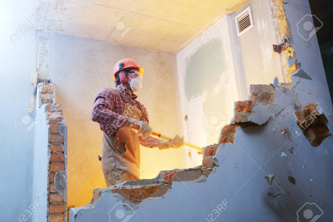 worker with sledgehammer at indoor wall destroying - 92406800 worker with sledgehammer at indoor wall destroying - 92406800
