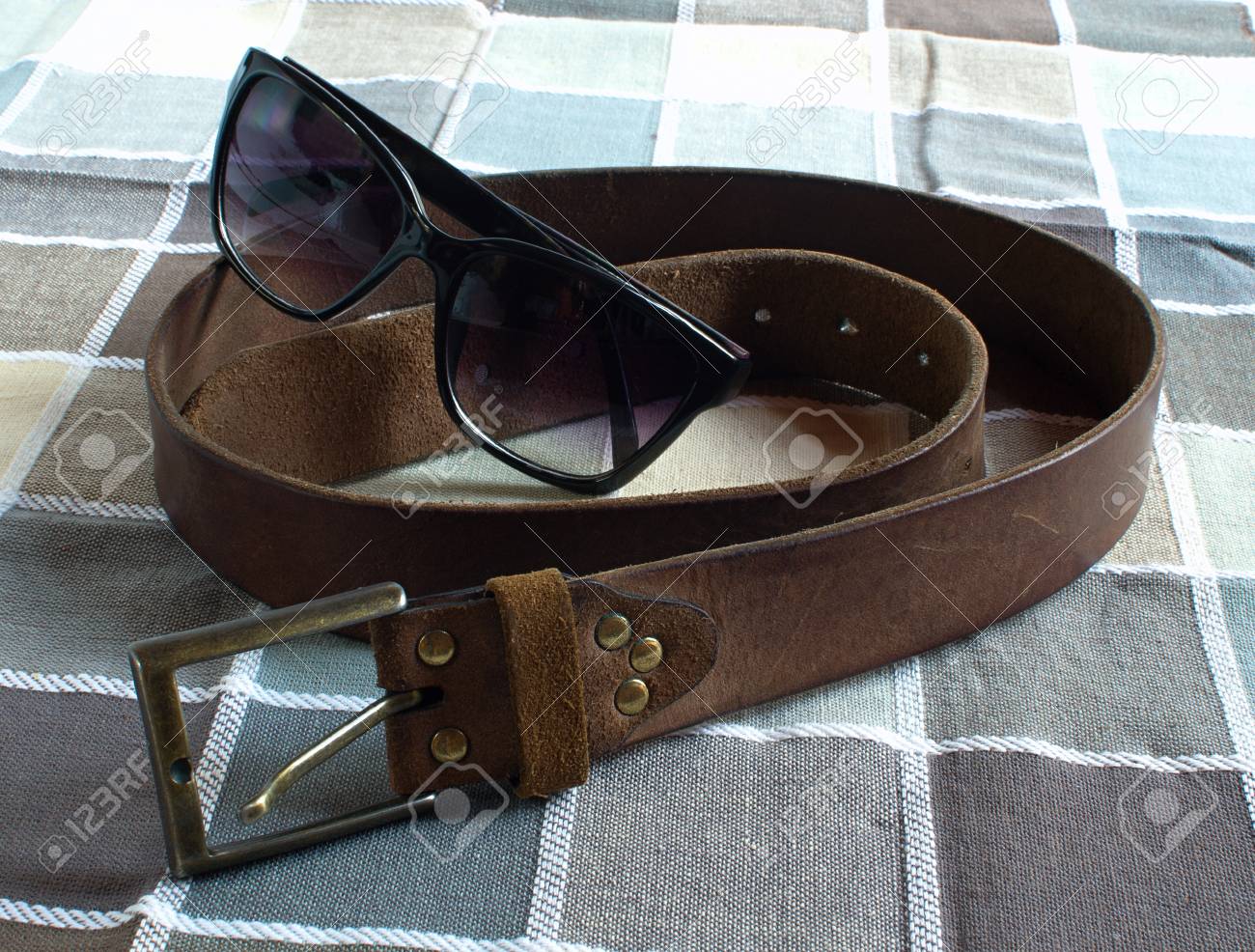 革ベルト 市松模様のファブリックの背景にメガネ の写真素材 画像素材 Image