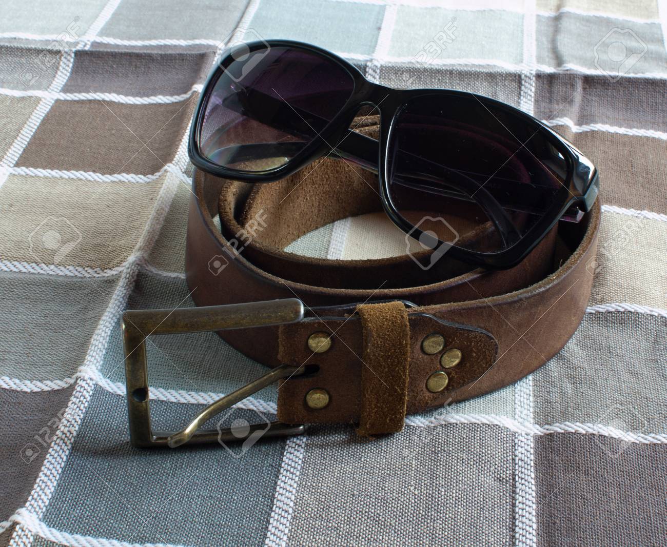 革ベルト 市松模様のファブリックの背景にメガネ の写真素材 画像素材 Image