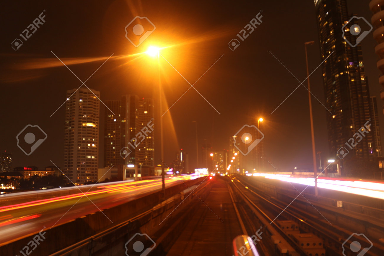 Bangkok City on February 22, 2020 at 11:06 pm: view from the driver's seat from a skytrain on the tracks in front with lightening effects at night with corporate buildings in background - 146066562 Bangkok City on February 22, 2020 at 11:06 pm: view from the driver's seat from a skytrain on the tracks in front with lightening effects at night with corporate buildings in background - 146066562