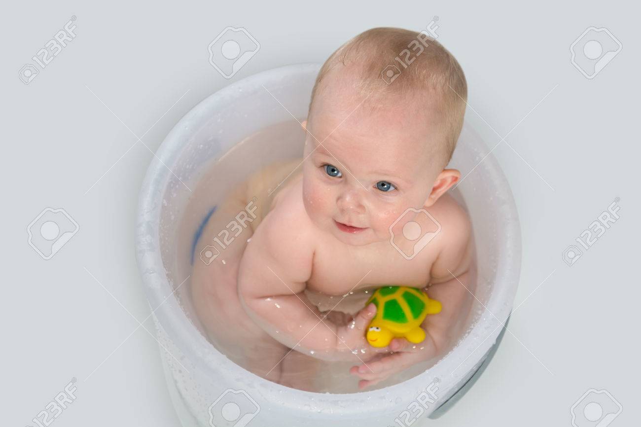 Les Yeux Bleus Petite Fille Dans Le Seau De Bain En Regardant La Camera Et Souriant Bebe Heureux De Prendre Un Bain Et De Jouer Avec Des Jouets En Caoutchouc Banque D Images