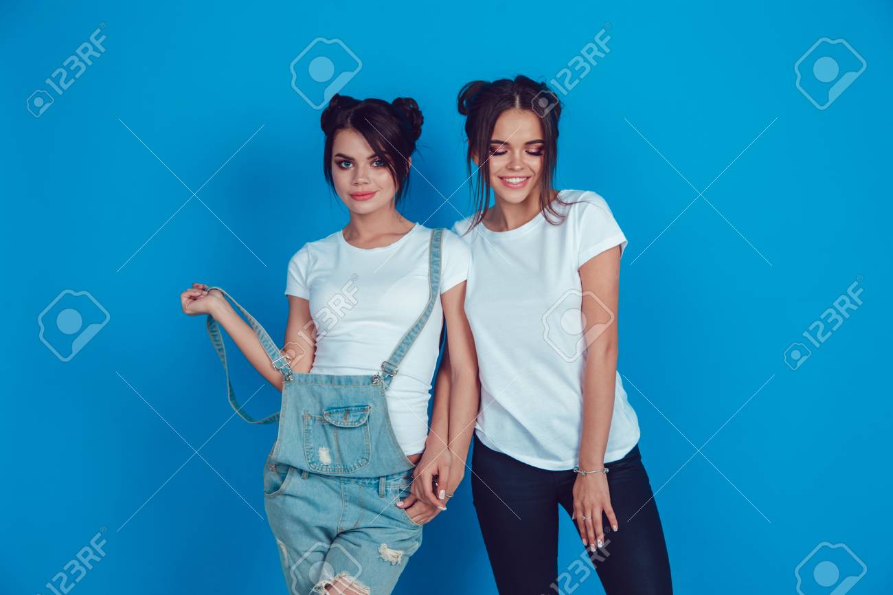 Attractive women in a white t-shirts stands on a blue background. Mock-up. - 94434596 Attractive women in a white t-shirts stands on a blue background. Mock-up. - 94434596