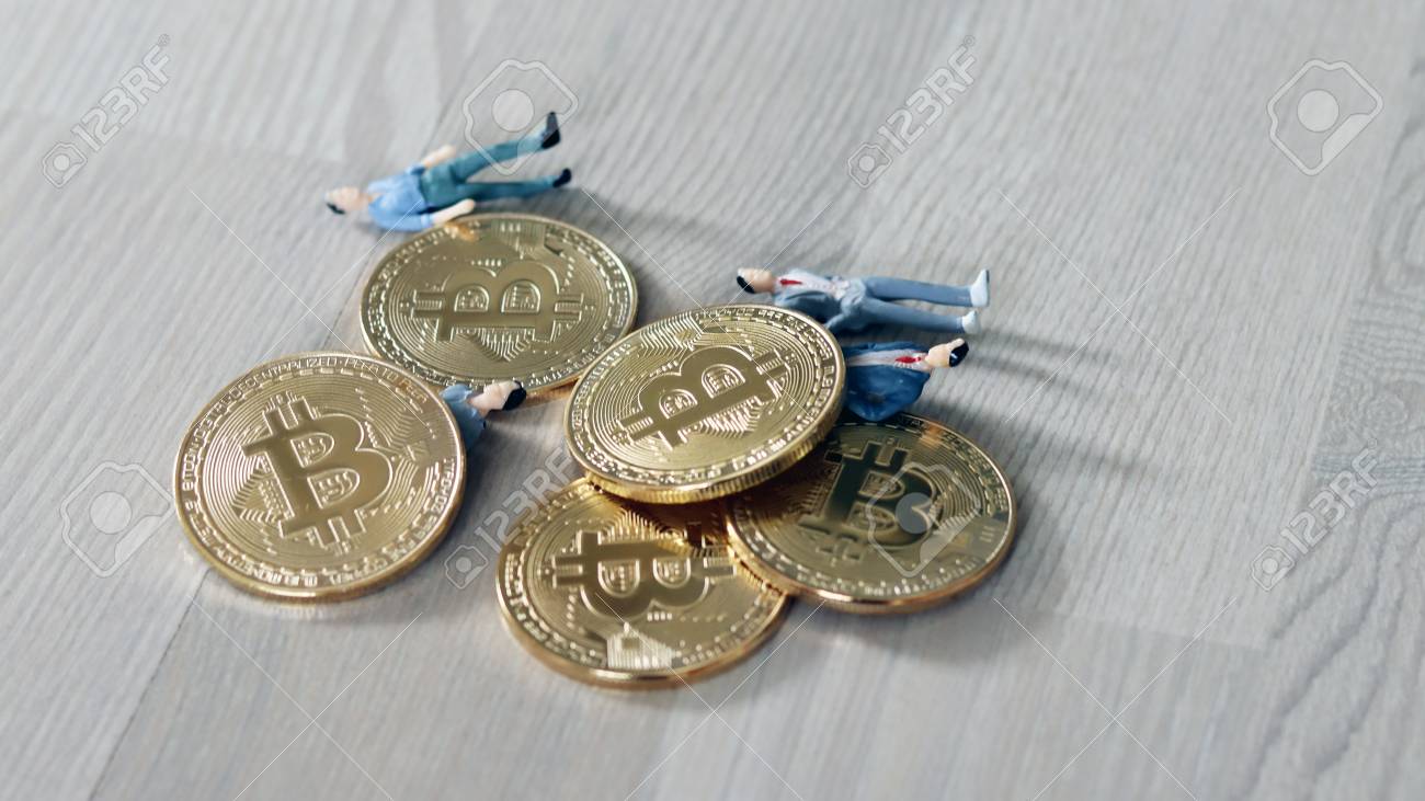 비트코인과 위험의 관계. 바닥에 누워 있는 미니어처 사람들과 비트코인. 로열티 무료 사진, 그림, 이미지 그리고 스톡포토그래피.  Image 96164924