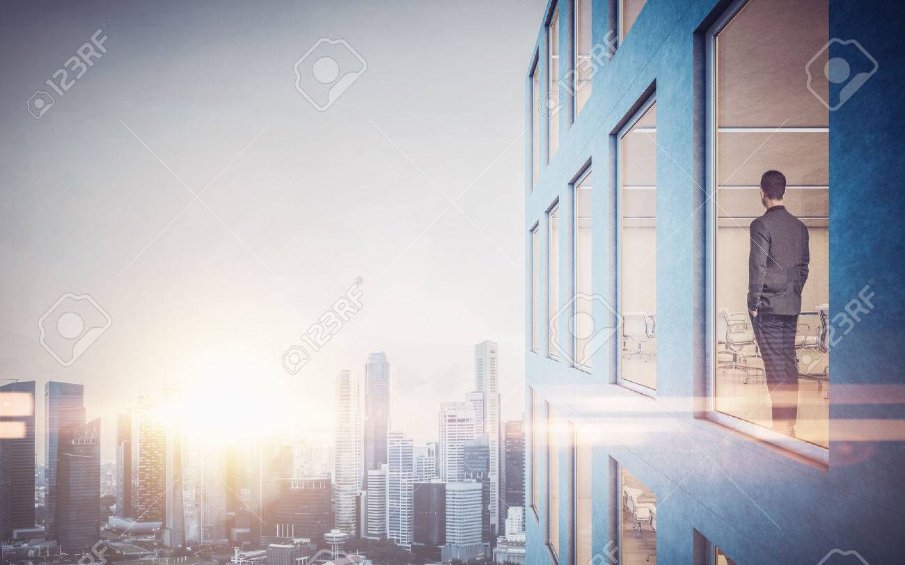 Businessman inside skyscraper, lookng at the city through the window. - 50793214 Businessman inside skyscraper, lookng at the city through the window. - 50793214