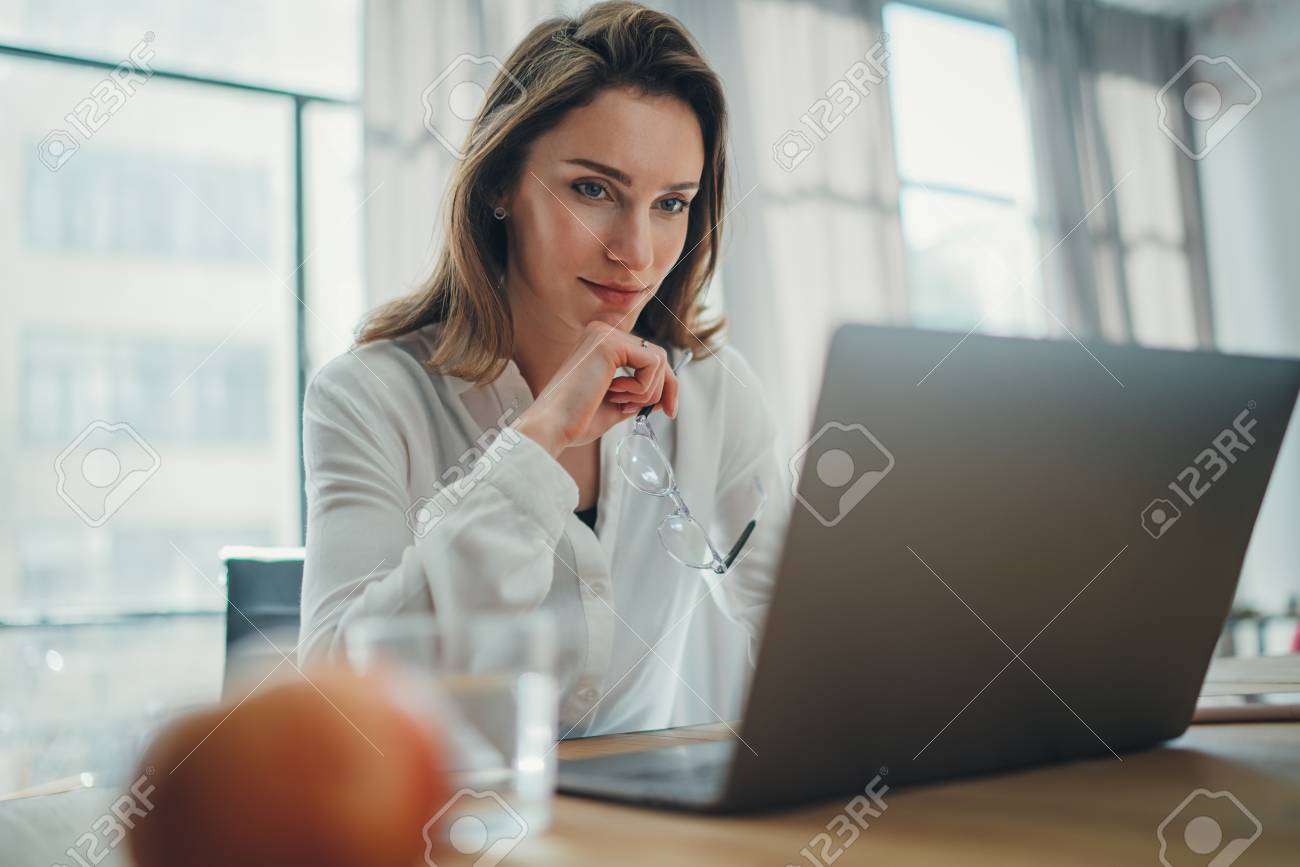 Handsome businesswoman working on laptop at her workplace at modern office.Blurred background. - 121282521 Handsome businesswoman working on laptop at her workplace at modern office.Blurred background. - 121282521