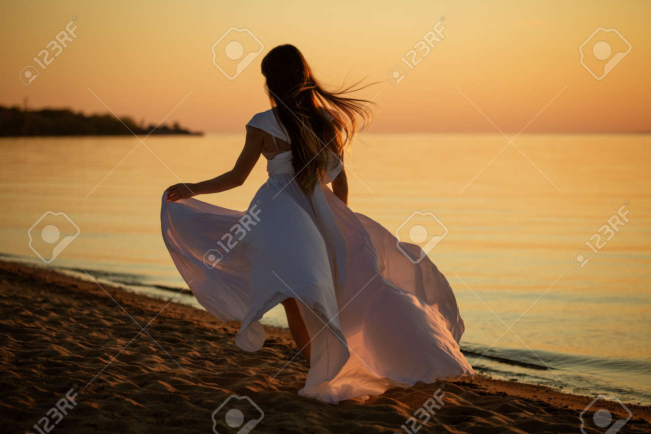 Young Free Woman Running In White Dress Near The Sea At Sunset Stock Photo,  Picture and Royalty Free Image. Image 163626262., image size:1300x867