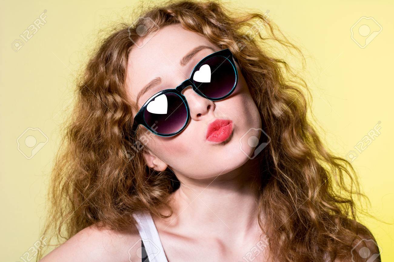 黄色の背景にキス唇をサングラスでかなり若い美女になります ハート型のサングラスに反映 の写真素材 画像素材 Image