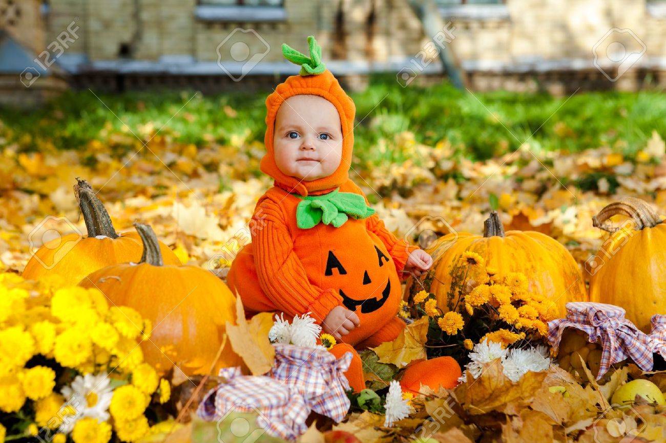 Child in pumpkin suit on background of autumn leaves - 22011091 Child in pumpkin suit on background of autumn leaves - 22011091