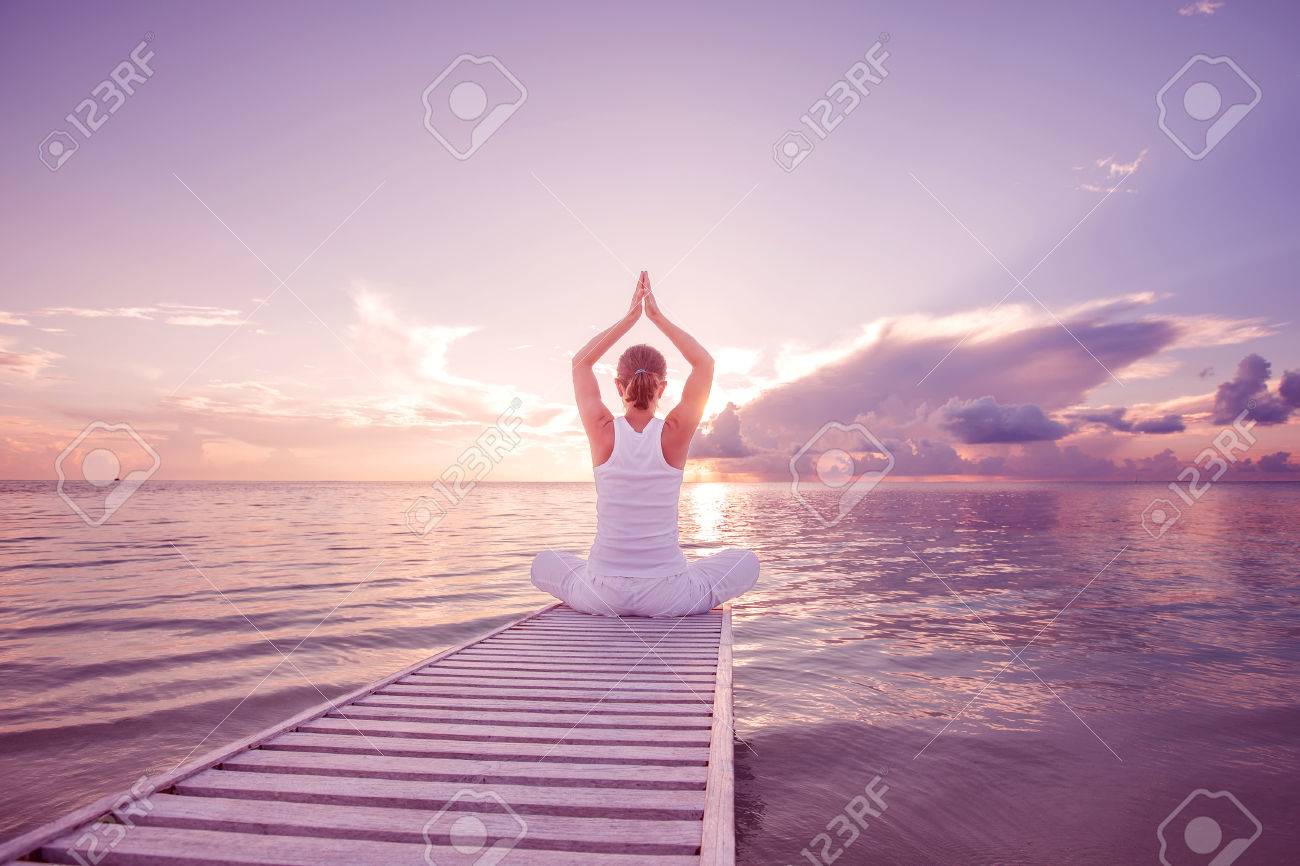 Caucasian woman practicing yoga at seashore - 22228288 Caucasian woman practicing yoga at seashore - 22228288
