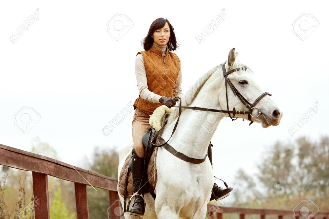 Woman jockey is riding the horse outdoor - 31364381 Woman jockey is riding the horse outdoor - 31364381