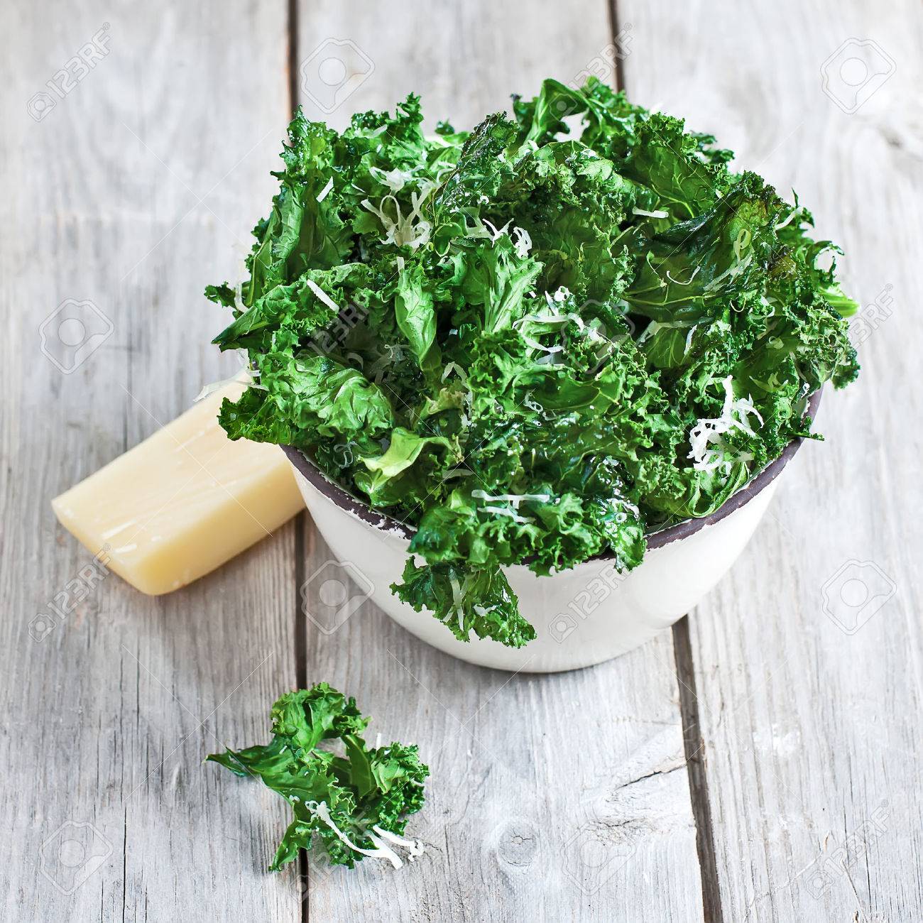 Kale chips with parmigano cheese in ceramic bowl. Selective focus. - 27910801 Kale chips with parmigano cheese in ceramic bowl. Selective focus. - 27910801