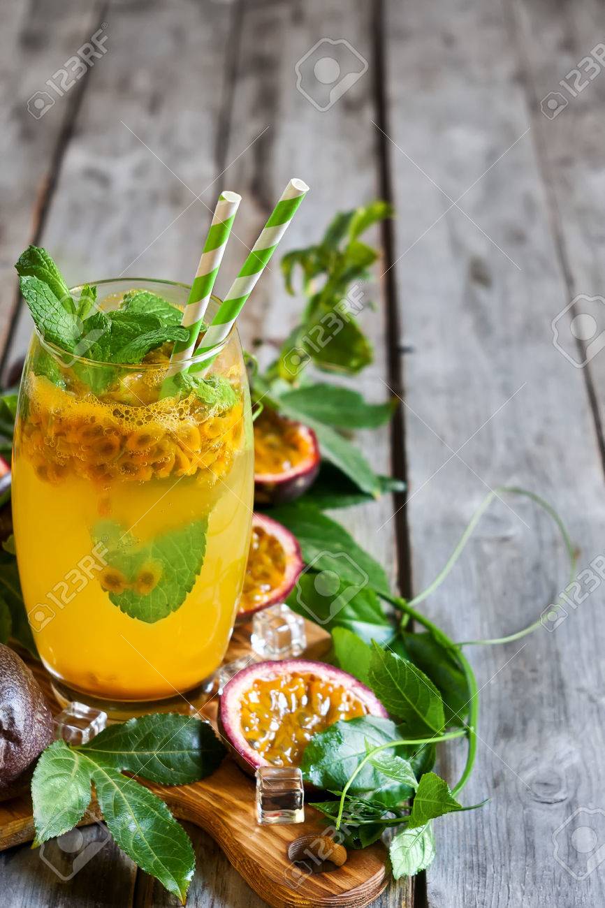 Homemade lemonade with passionfruit, mint leaves and ice cubes on old wooden background. Copy space background. - 41255882 Homemade lemonade with passionfruit, mint leaves and ice cubes on old wooden background. Copy space background. - 41255882